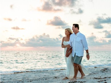 Breast cancer survivor Catherine Haffey walking on the beach with her husband